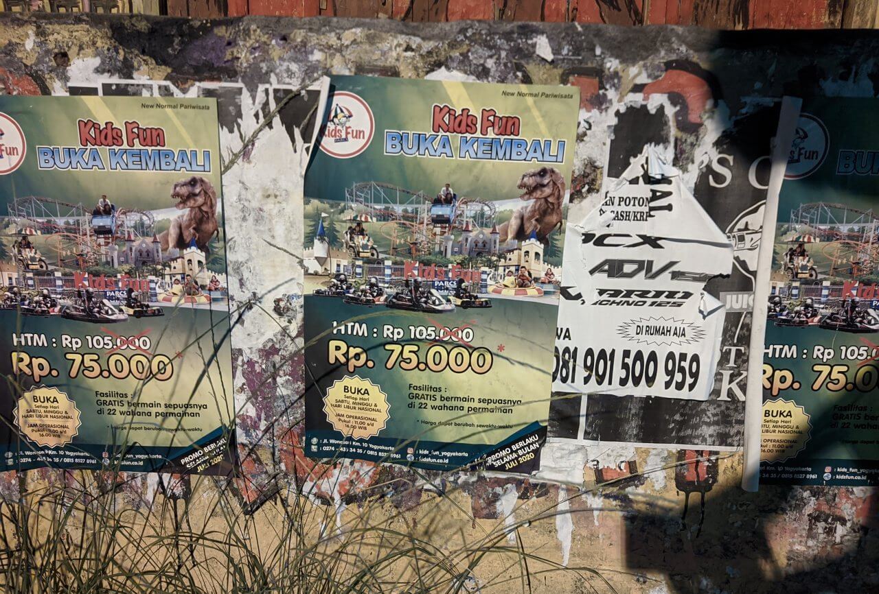 Penampakan dinding jalan yang penuh dengan sampah iklan